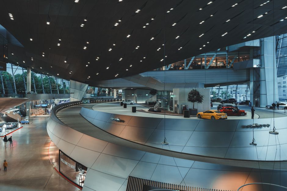 Interior view of BMW Welt showcasing sleek design and luxury cars in Munich, Germany.