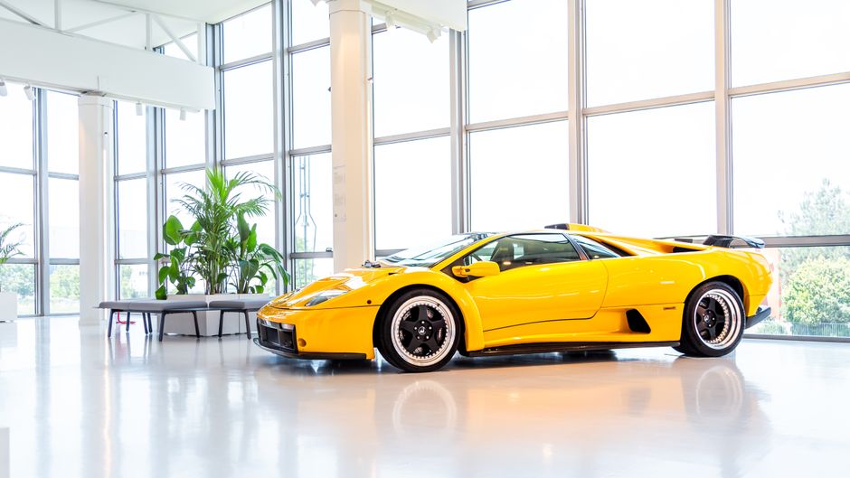 A stunning yellow Lamborghini supercar on display in a bright, modern showroom setting.